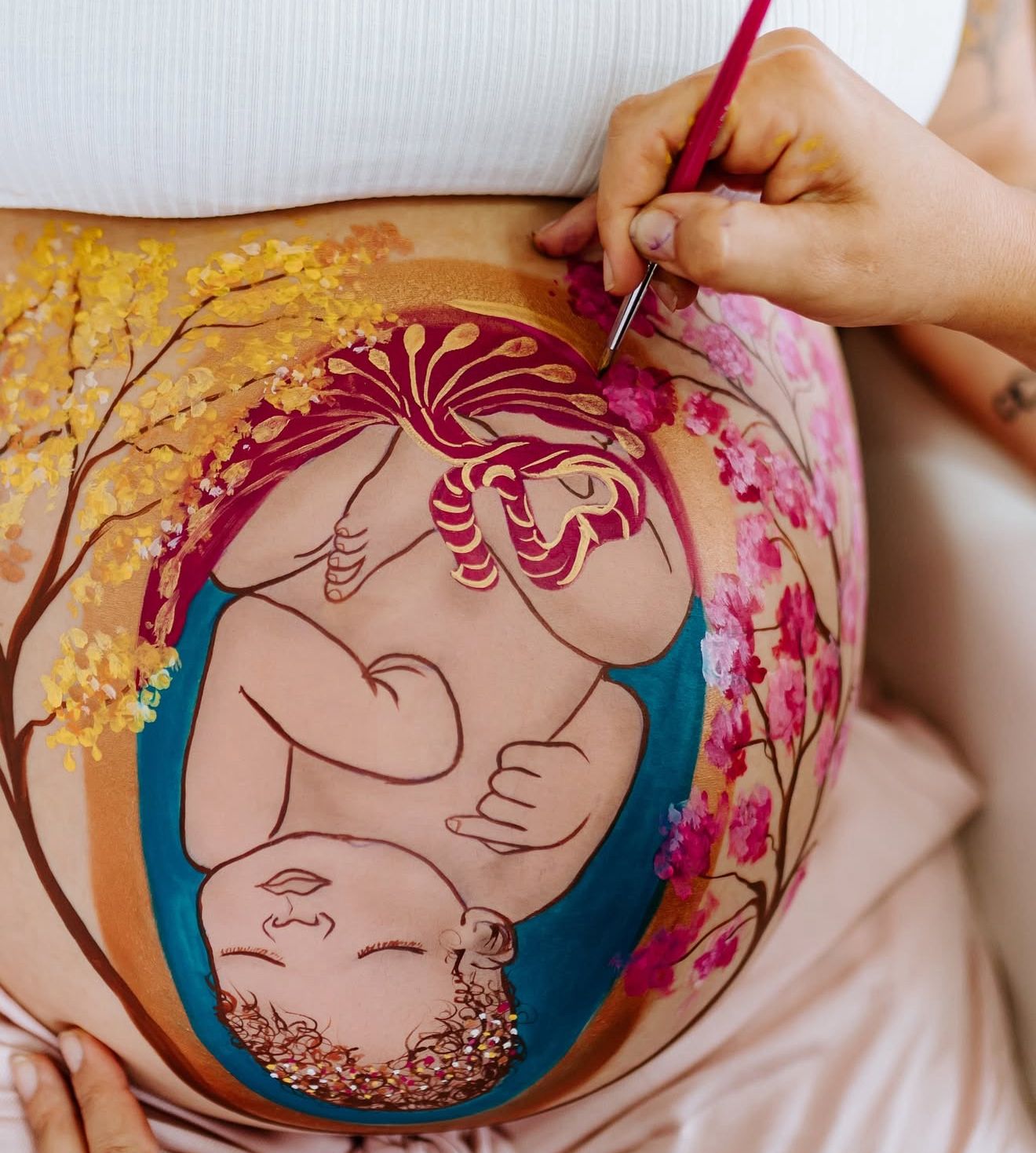 Pintura de bebê com flores rosas e amarelas sendo finalizada